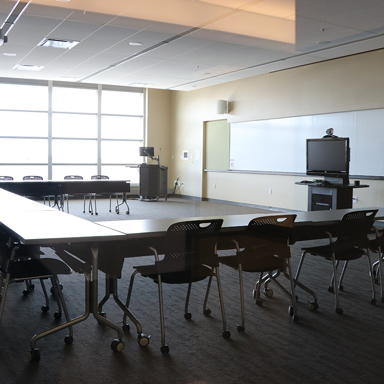Empty meeting room with audio visual equipment setup in it.